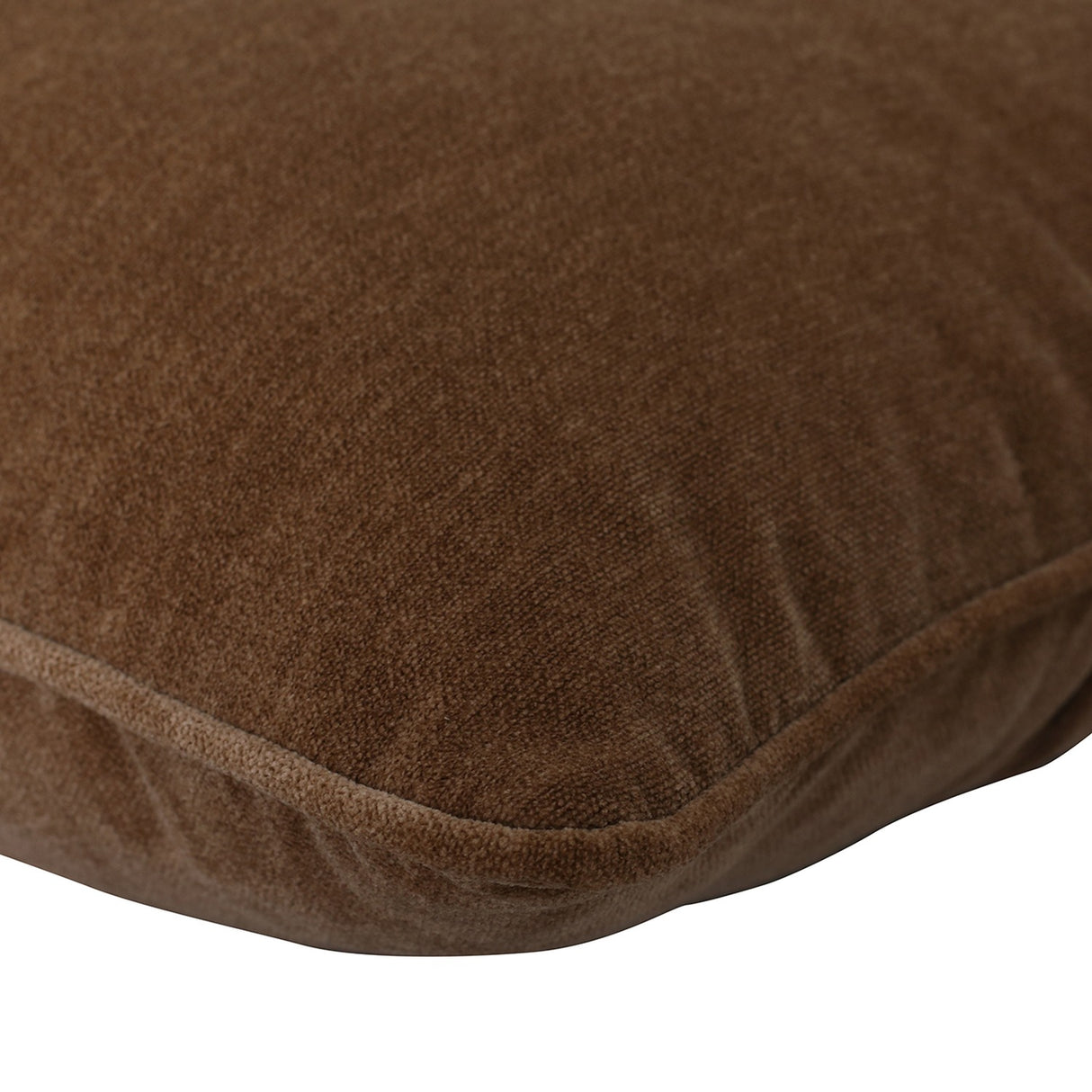 Close-up of the Libra Interiors Piped Plush Velvet Cushion in brown, showing the low-pile velvet surface and corded piping along the seamed edge.