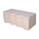 Libra Interiors Velvet Lift-Top Storage Ottoman in cream with a softly sculpted wave-front profile and smooth padded top, shown on a plain white background.