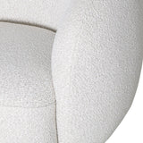 Close-up of the Libra Interiors Bouclé Swivel Accent Armchair in cream, showing the textured looped weave across its rounded seat and curved arm.
