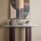 Libra Interiors Marble Top Fluted Walnut Console Table in brown with oval grey marble top, styled with a vase, book and bowl below abstract art.