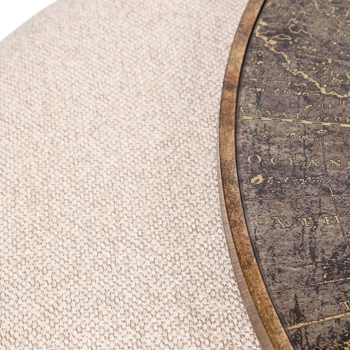 Close-up of Libra Interiors Round Map-Print Glass Nesting Coffee Table showing the printed world map glass top, brass-toned frame, and cobble-weave pouffe.