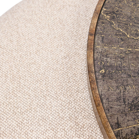 Close-up of Libra Interiors Round Map-Print Glass Nesting Coffee Table showing the printed world map glass top, brass-toned frame, and cobble-weave pouffe.