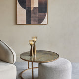 Libra Interiors Round Map-Print Glass Nesting Coffee Table with brass-toned frame and grey cobble-weave pouffe, styled with candle holders in a living room.
