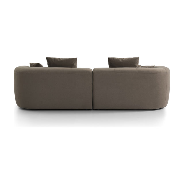 Rear view of Libra Interiors Velvet Curved 2-Seater Modular Sofa in truffle, showing rounded two-section form and scatter cushions on white.