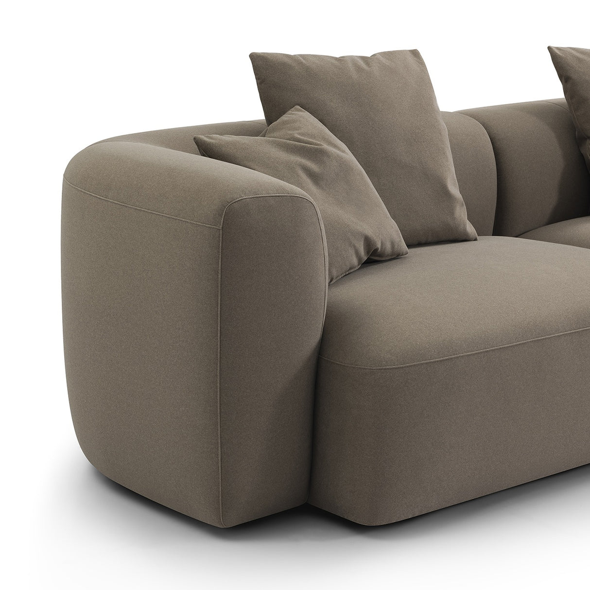 Close-up of the Libra Interiors Velvet Curved 2-Seater Modular Sofa in truffle, showing the rounded arm, deep seat and loose scatter cushions.
