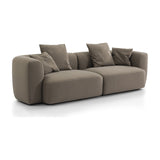 Libra Interiors Velvet Curved 2-Seater Modular Sofa in truffle beige with rounded sculptural frame, deep seats and loose scatter cushions on a white background.