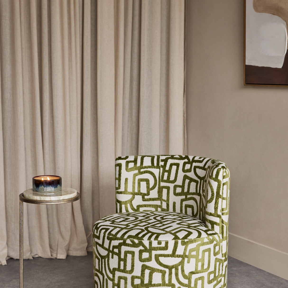 Libra Interiors Bouclé Swivel Accent Piece in ivory with olive green abstract pattern, styled in a room with linen curtains and a marble side table.