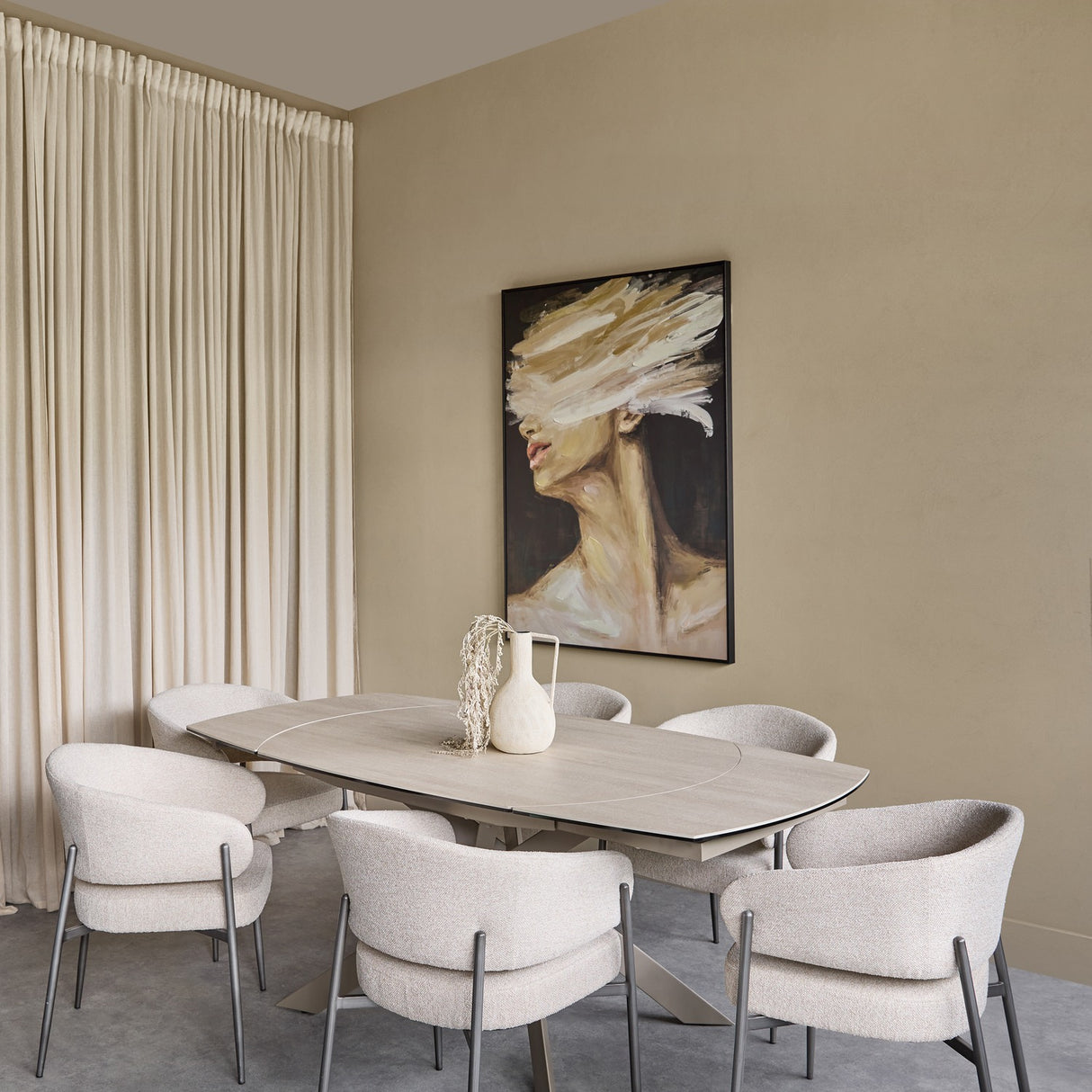 Libra Interiors extendable ceramic dining table in warm stone with brushed grey metal base, styled with boucle chairs in a neutral dining room.