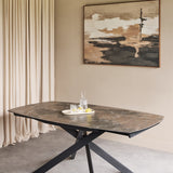 Libra Interiors extendable dining table with smoked grey ceramic stone-effect top and matt black angular metal legs, styled with a drinks tray.