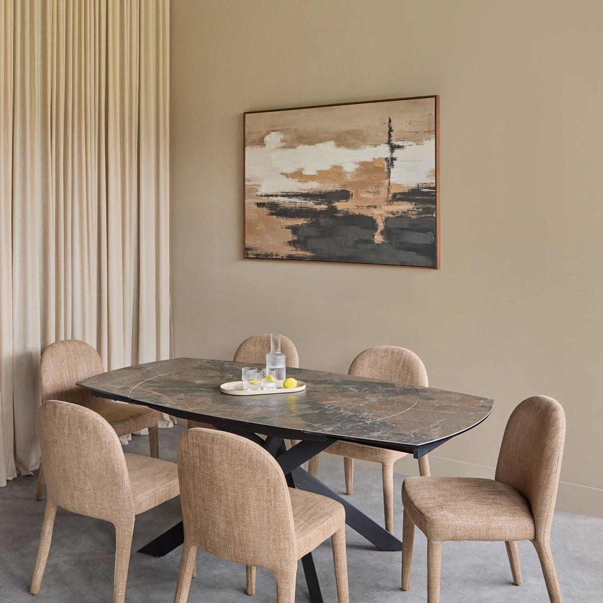 Libra Interiors extendable dining table with smoked grey ceramic top and matt black angular base, set with six beige upholstered chairs below abstract wall art.