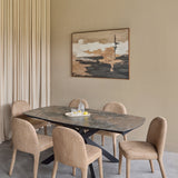 Libra Interiors extendable dining table with smoked grey ceramic top and matt black angular base, set with six beige upholstered chairs below abstract wall art.