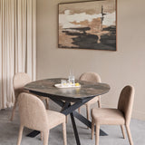 Libra Interiors extendable ceramic dining table with smoked grey stone-effect top, matt black angular metal base, and four neutral upholstered chairs.