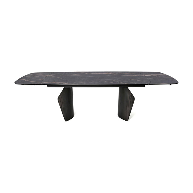 Libra Interiors extendable dining table with a charcoal ceramic stone-effect top, bronze veining, and dark wood-effect pedestal legs on a white background.