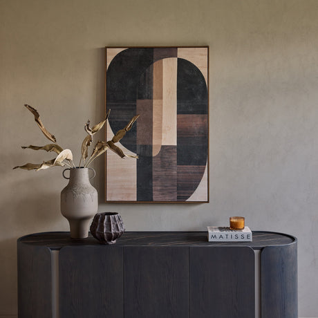 Libra Interiors Ceramic Top Curved Sideboard in charcoal styled with a ceramic vase, dried leaves and geometric artwork against a warm neutral wall.