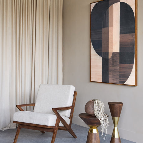Libra Interiors Atherton mango wood armchair with angular dark timber frame and cream woven cushions, styled beside linen curtains and geometric wall art.