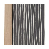 Close-up of the Black & Beige Abstract Canvas with Natural Frame, showing vertical white brushstroke stripes on a charcoal canvas beside a light wood frame edge.