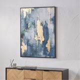 Gold & Blue Tone Abstract Canvas with black frame, 90 x 120cm, shown above a wooden sideboard in a room with textured light grey walls.