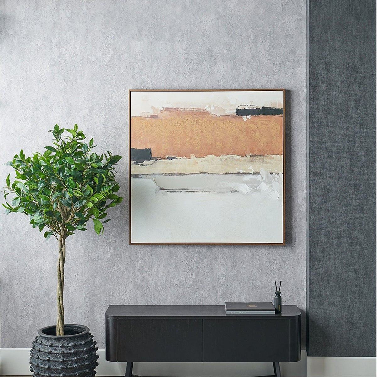 White & Terracotta Abstract Square Canvas in an oak effect frame, hung above a black sideboard with a potted plant beside it against a textured grey wall.