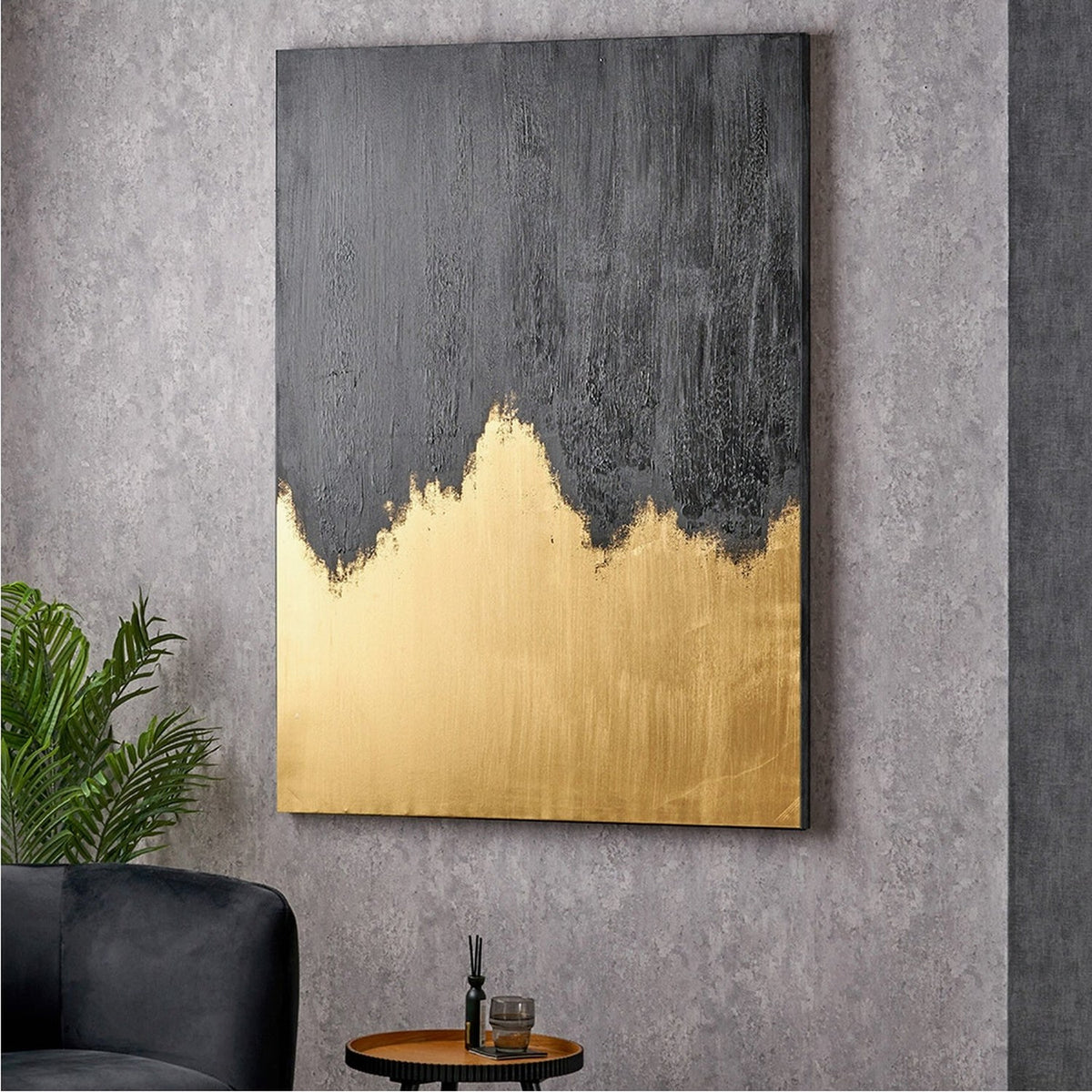Textured black and gold abstract frameless canvas wall art, 100 x 140cm, with jagged gold base and charcoal texture above, shown mounted in a grey-toned living room.