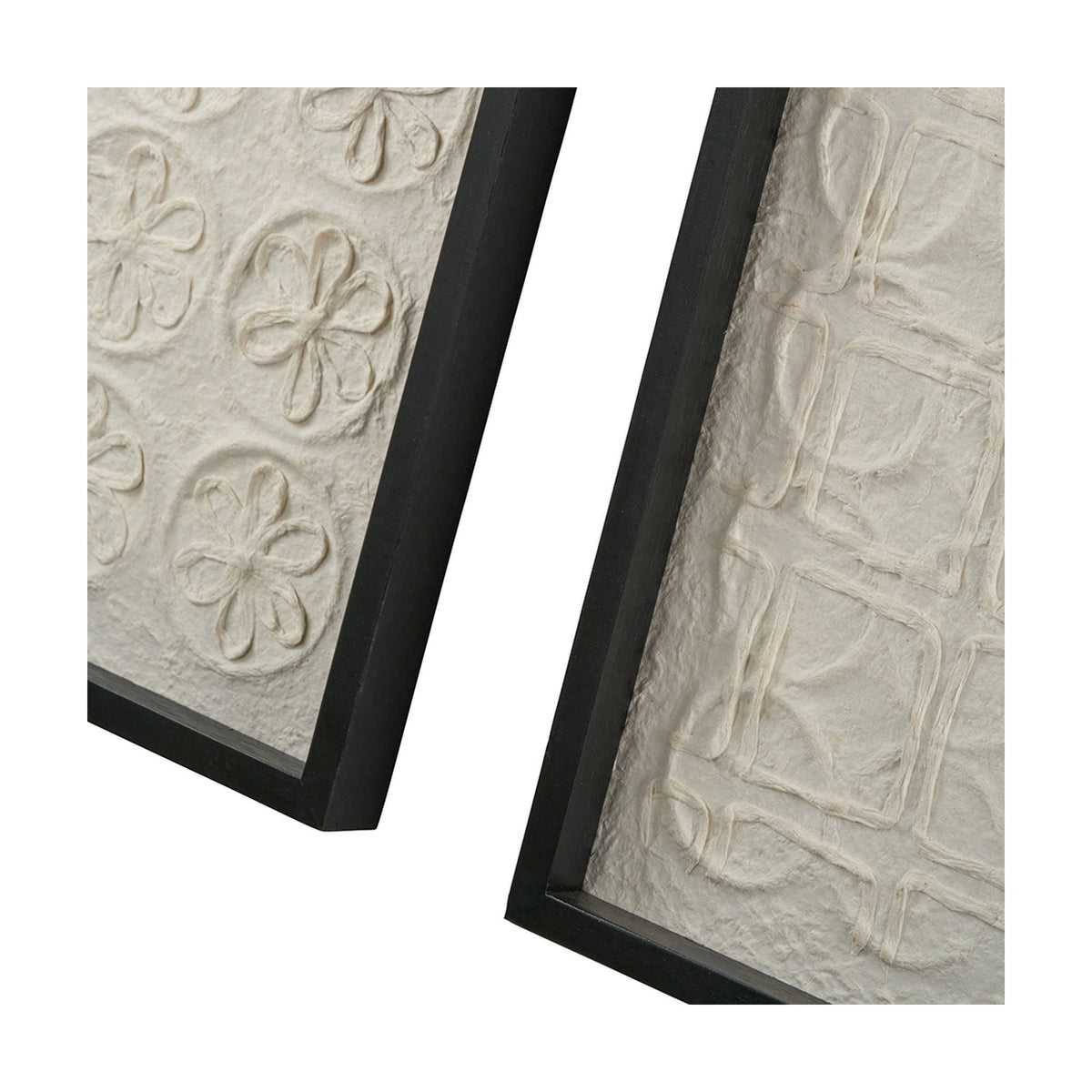 Close-up of two natural paper wall art panels in black frames, one with raised floral discs, the other with a linear square pattern, on a white background.