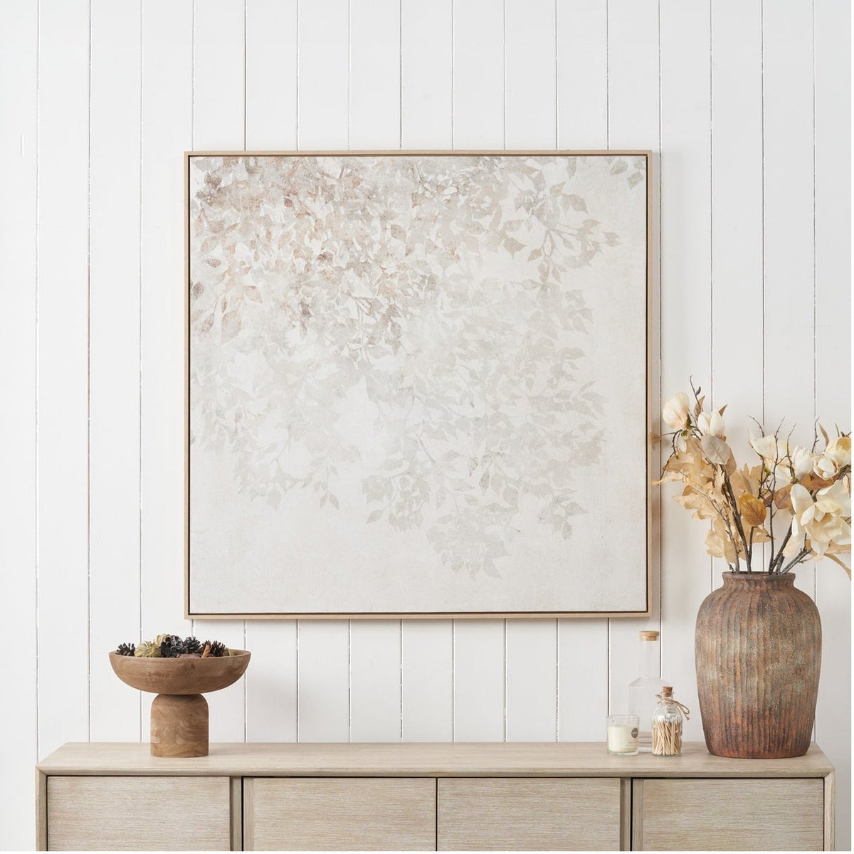 White & Natural Floral Square Canvas, 100 x 100cm, wood-framed wall art with soft leaf pattern, displayed above a wooden sideboard with vase and decor.