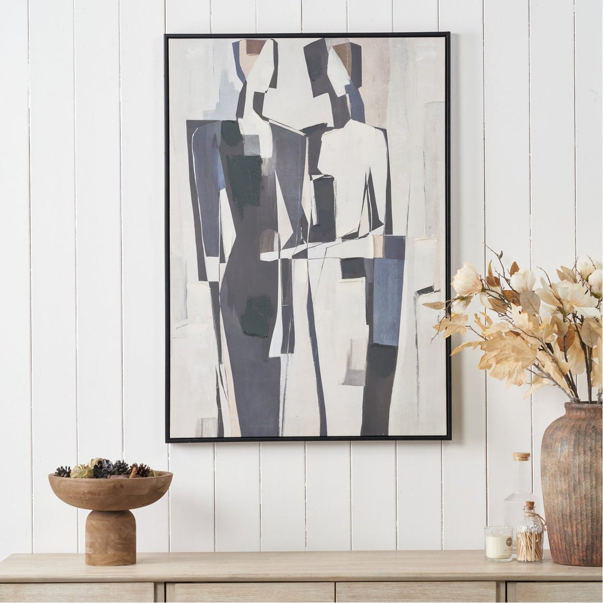 Monochrome Abstract People Canvas, 70 x 100cm, black frame, displayed above a sideboard on a white panelled wall in a styled living space.