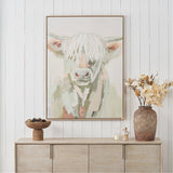 Sage & Naturals Highland Cow Canvas with Natural Frame, 90 x 120cm, hung above a wooden sideboard styled with a vase, candle, and pinecone bowl.