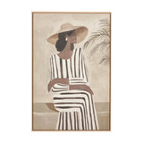 Canvas wall art in a natural wood frame depicting a woman in a wide-brimmed hat and striped dress seated beside a palm plant, on a plain background.