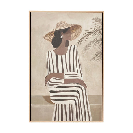 Canvas wall art in a natural wood frame depicting a woman in a wide-brimmed hat and striped dress seated beside a palm plant, on a plain background.