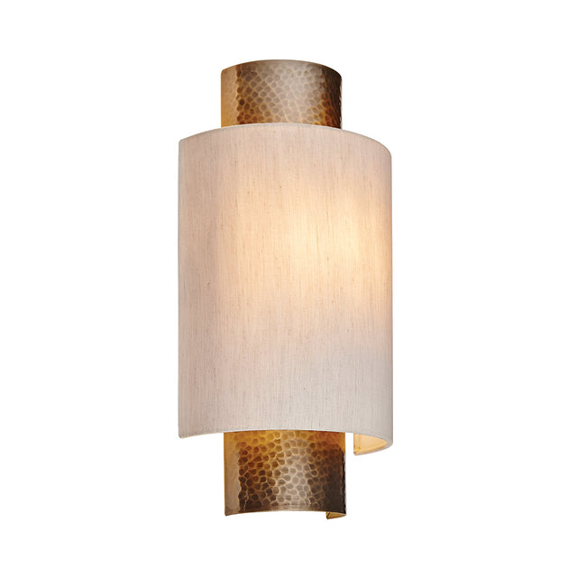 Endon Brenwood wall light with hammered aged bronze fitting and natural linen-effect fabric shade, shown illuminated on a plain white background.