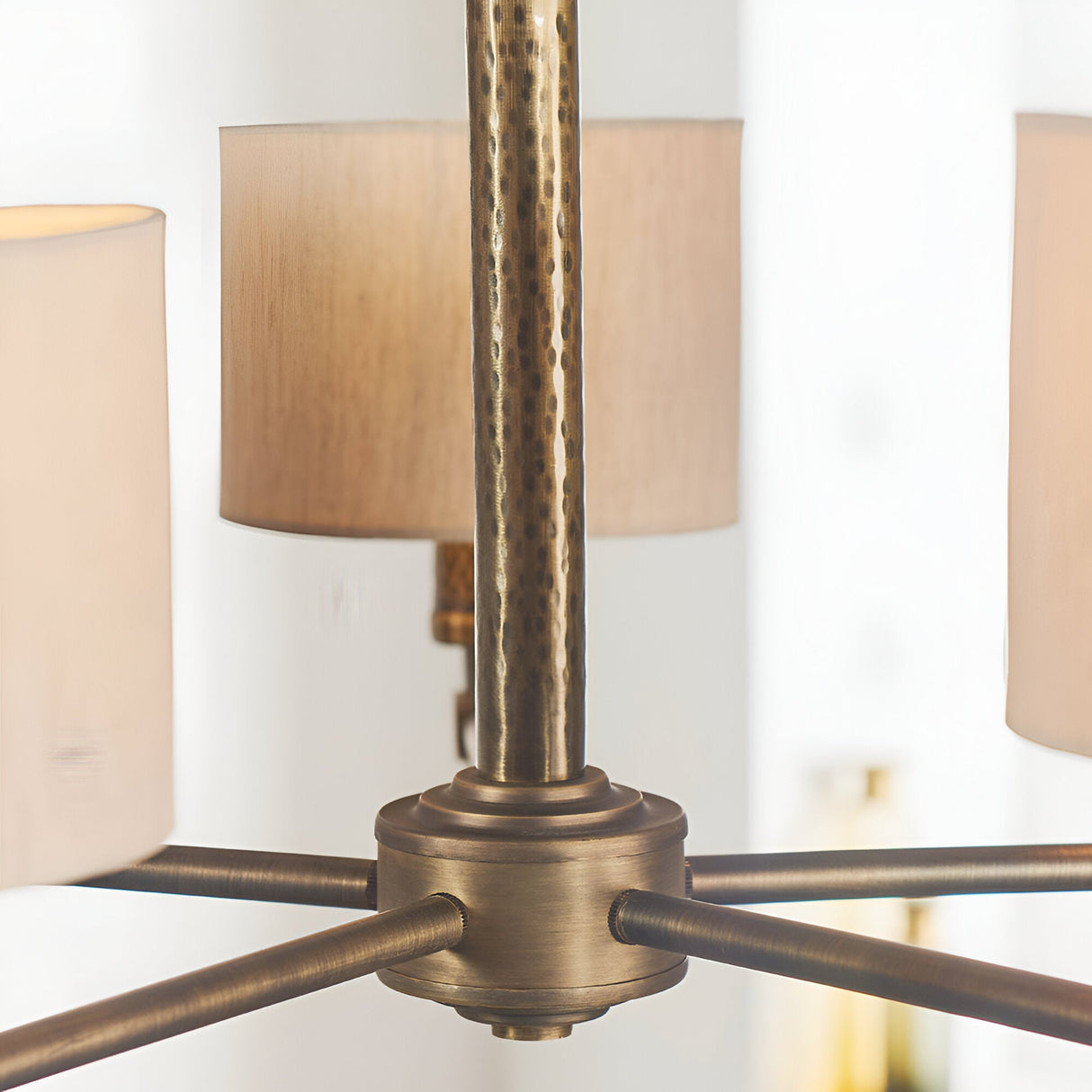 Close-up of the Endon Brenwood 5 Light Pendant showing the hammered bronze centre plate, arms and natural linen effect fabric shades.