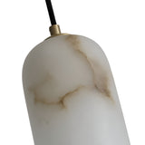 A close-up of the Velmora 1 Light Slim Cylindrical Alabaster Single Pendant Light in soft white with brown marbled veins, a black cord, glossy finish, and an elegant brass ceiling plate for a minimalist look.