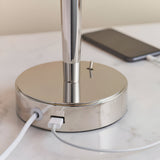 Close-up of the Endon Crandale table lamp's nickel base with built-in USB port charging a phone via white cable on a marble surface.