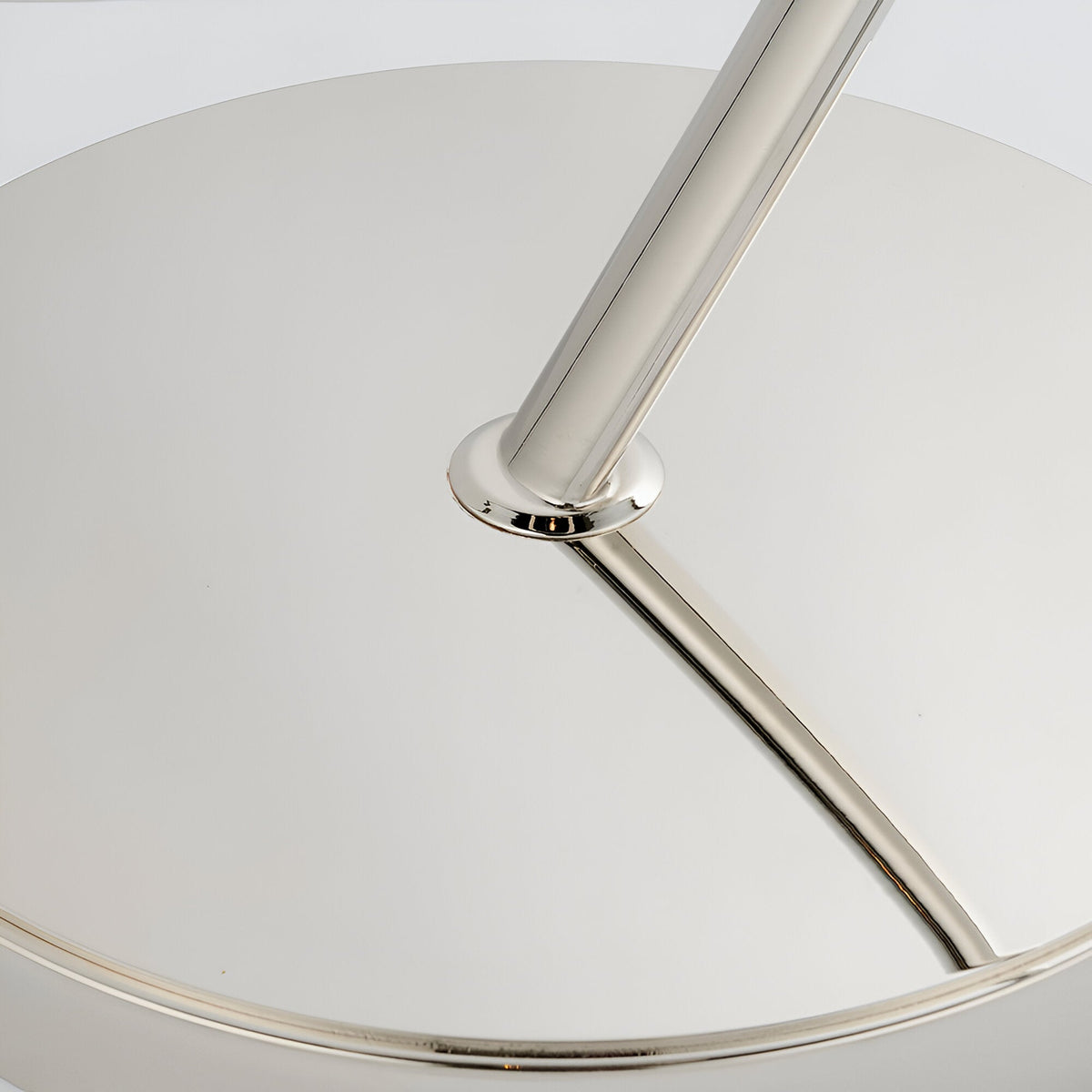 Close-up of the Brockfield Floor Lamp's polished nickel stem and angled arm, showing the metal joint against a white shade on a plain background.