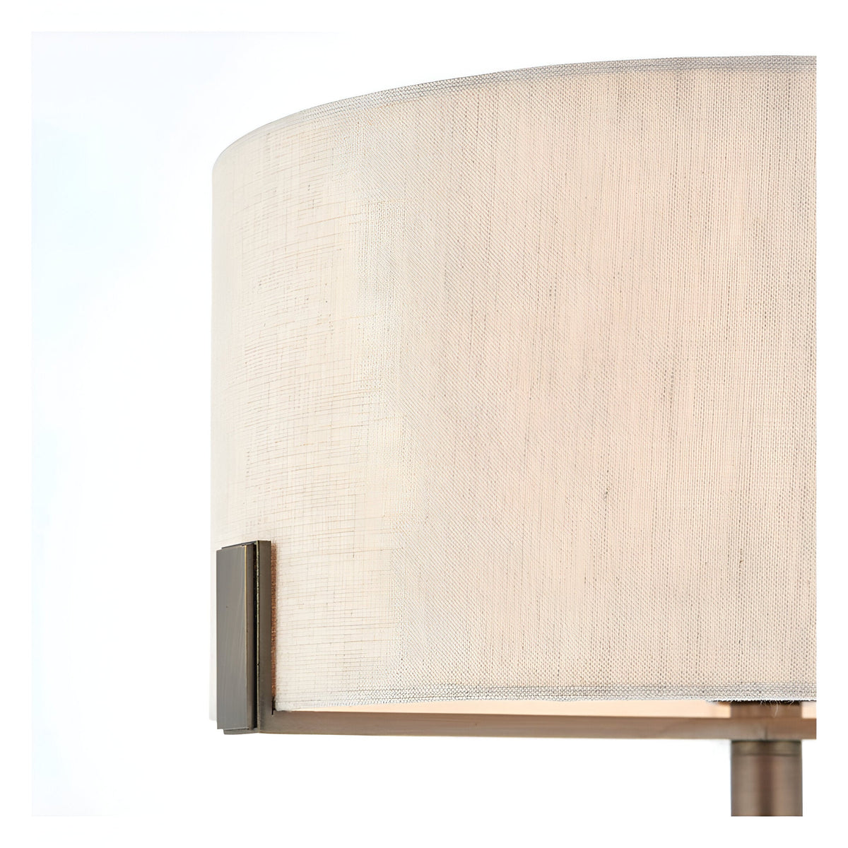 Close-up of the Brendon Table Lamp's natural linen drum shade with bronze bracket detail, set against a plain white background.