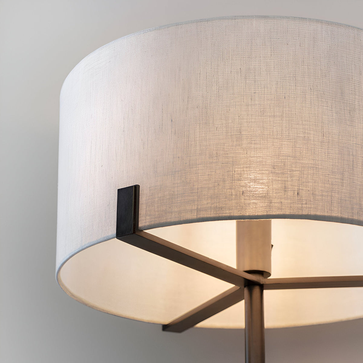 Close-up of the Endon Brendon floor lamp showing the natural linen drum shade supported on slim brushed bronze metalwork.