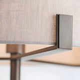 Close-up of the Endon Brendon floor lamp showing the slim bronze metalwork bracket supporting the natural linen fabric shade.