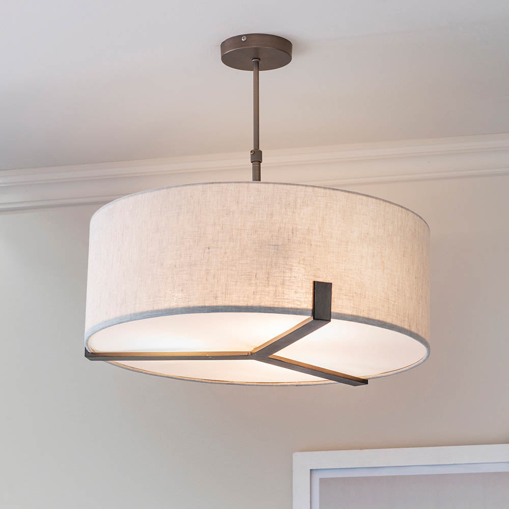 Brendon 3 Light Pendant in bronze, large drum-shaped fabric shade with metal frame, adjustable stem, shown hanging in a room setting.
