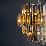 Endon Danedale 15 light chandelier in polished chrome with tiered tinted champagne bevelled crystals, illuminated against a dark grey background.