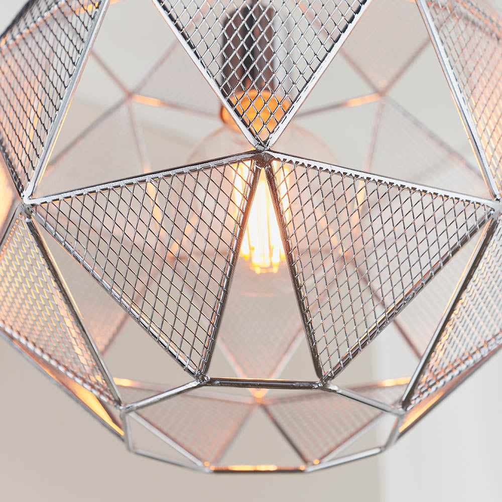 Aldford Pendant in polished chrome, close-up of geometric mesh triangle shade with visible E27 bulb glowing inside.
