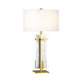 The Orinth 1 Light Framed Alabaster Column Table Lamp features a brass frame, rectangular white marble base, and a large white drum shade, shown against a plain white background.