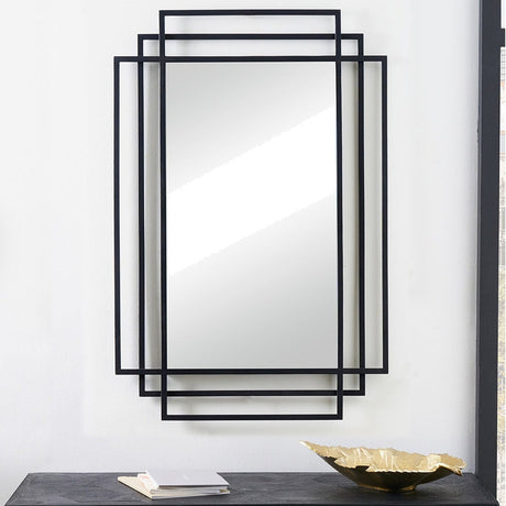 Black Iron Art Deco rectangular wall mirror with layered stepped frame, hung above a dark console table with a book and gold decorative dish.