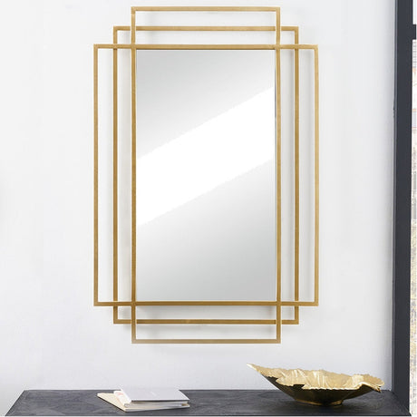Gold iron Art Deco rectangular wall mirror, 61 x 92cm, with layered geometric frame, shown above a dark console table with a gold dish and books.