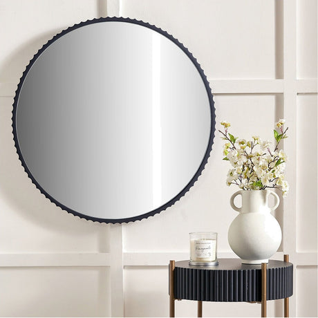 Black Aluminium Textured Edged Round Wall Mirror, 70 x 70cm, hung on a panelled wall above a side table with a white vase and flowers.