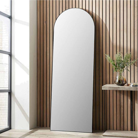 Slim Frame Black Stainless Steel Arch Floor Mirror, 70 x 200cm, leaning against a wood-slatted wall in a hallway beside a console table with a glass vase.