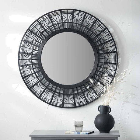 Round black bamboo frame wall mirror, 90 x 90cm, with decorative sunburst pattern, displayed above a grey console table with a vase and dried grasses.