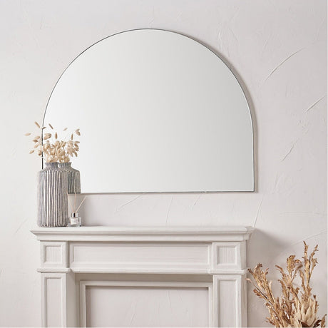 Slim Frame Brushed Silver Metal Wide Arch Wall Mirror, 120 x 90cm, mounted above a white mantelpiece with dried floral vases in a light-toned living room.