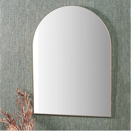 Slim Frame Brushed Gold Metal Tall Arch Wall Mirror, 90 x 120cm, mounted on a textured green wall with decorative dried foliage beside it.