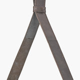 Close-up of the Peppercorn Leather Frame Wall Mirror's crossed leather straps with stitched edges and a stud fastening, shown against a plain white background.