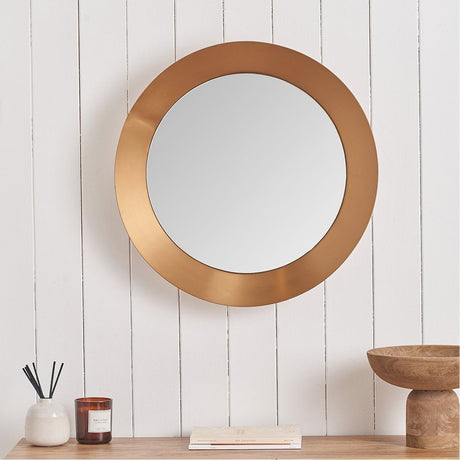 Round wall mirror with a burnished gold angled aluminium frame, 60 x 60cm, shown on a white panelled wall above a wooden console table.